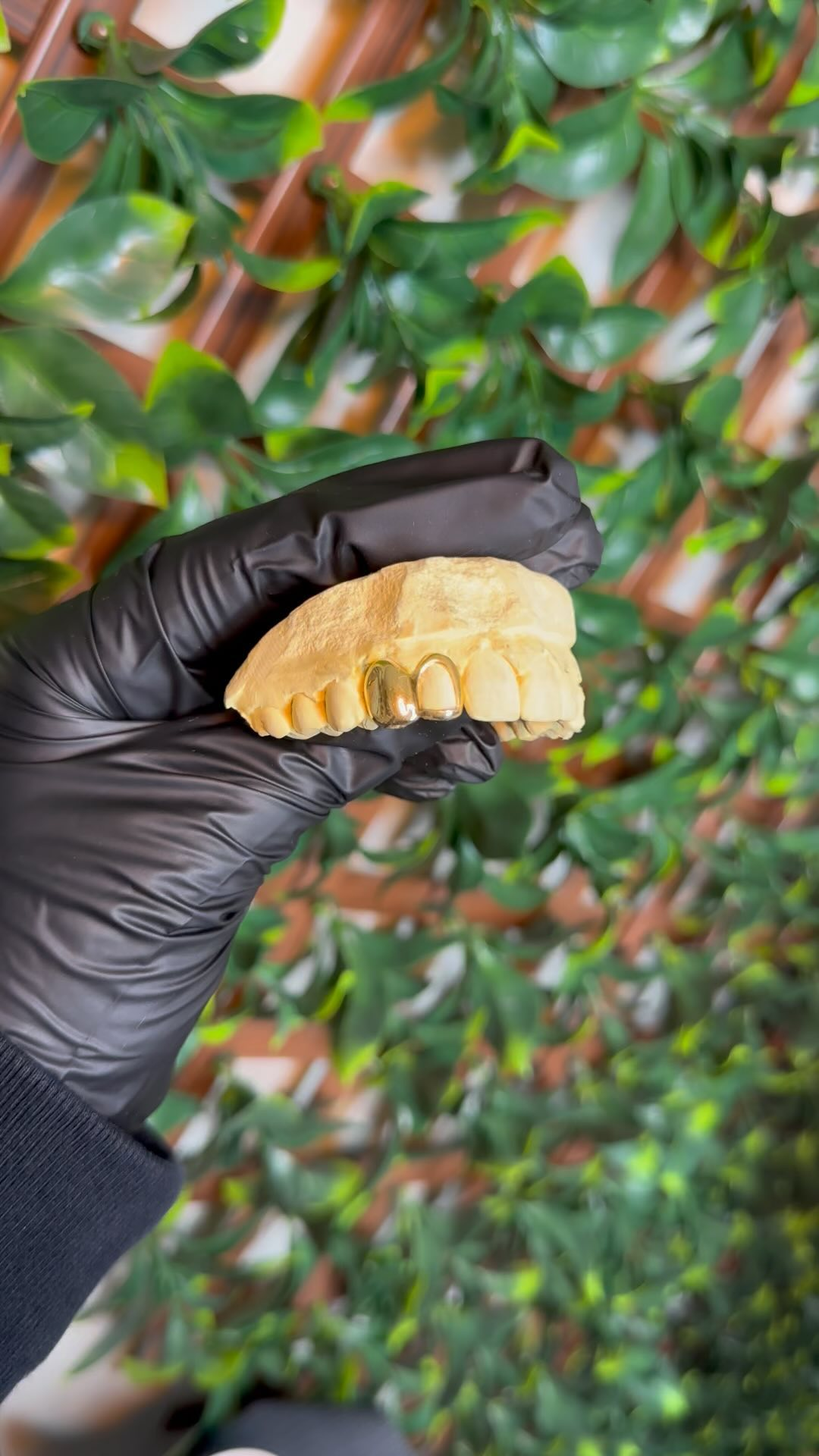 Gold grillz mold in black glove